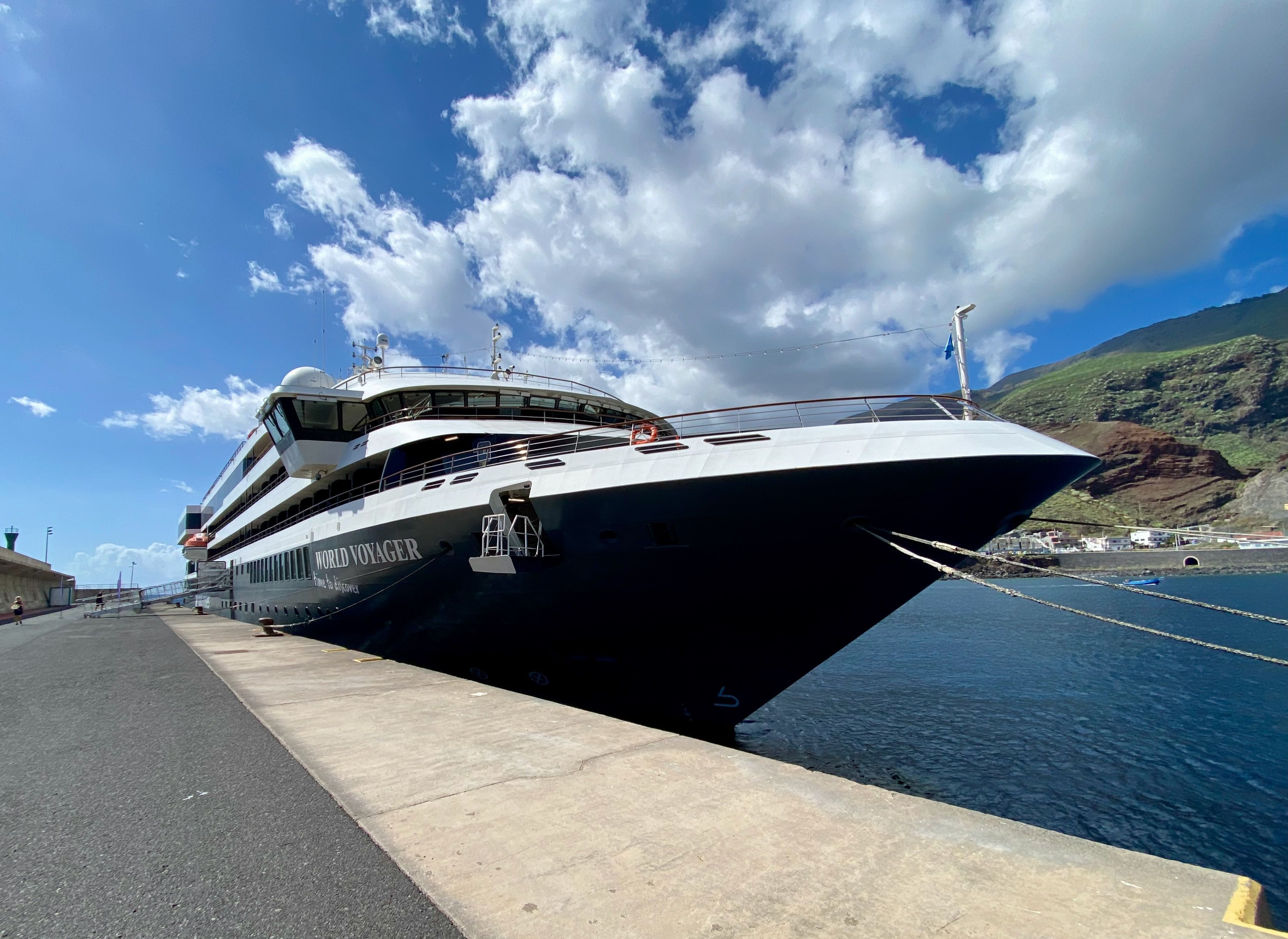 World Navigator Kreuzfahrtschiff im Hafen aus niedriger Perspektive mit blauem Himmel und Küstenlandschaft