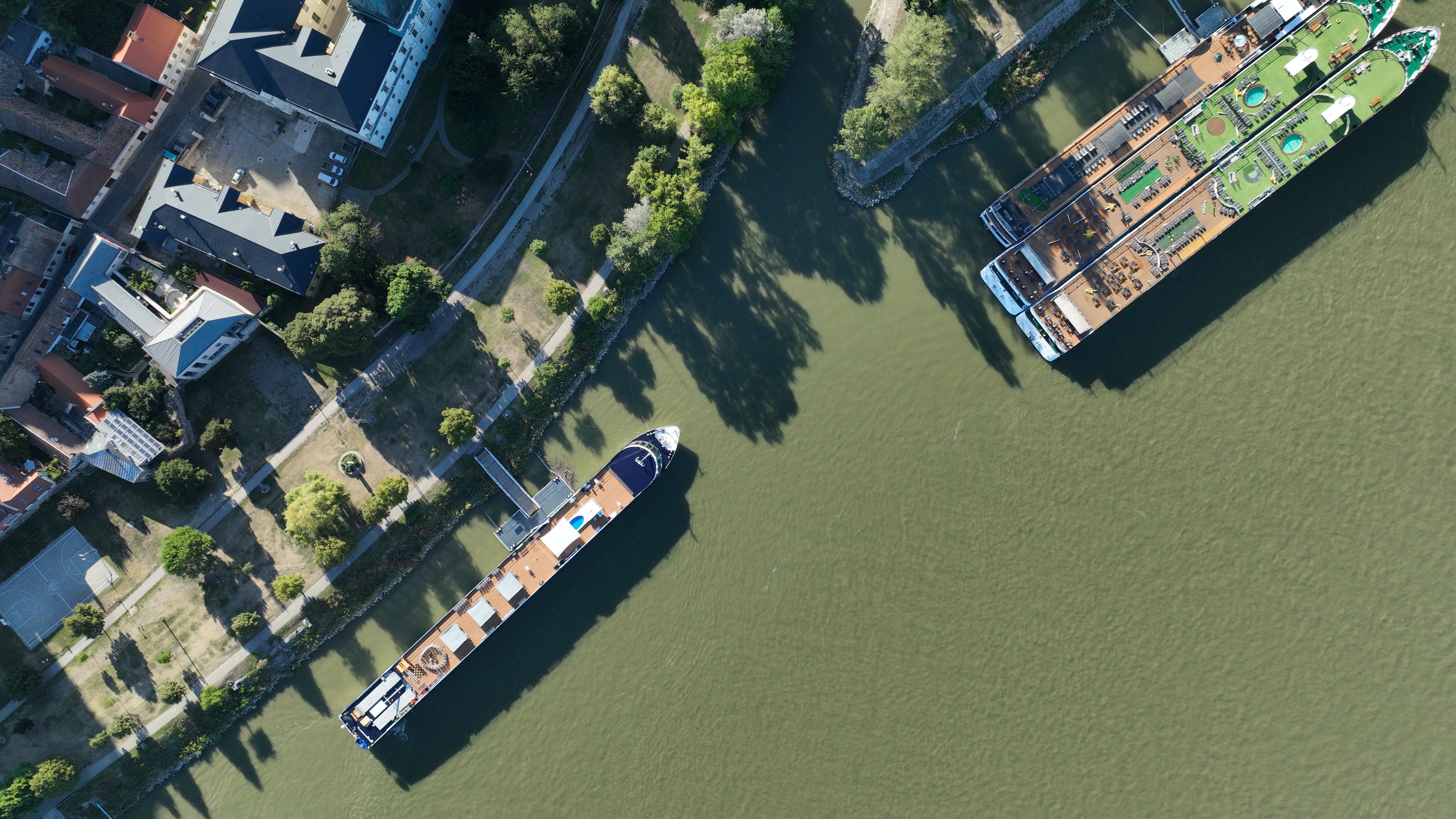 Luftaufnahme eines Kreuzfahrtschiffs am Flussufer, Stadtansicht und Anleger für eine Reise mit Hund