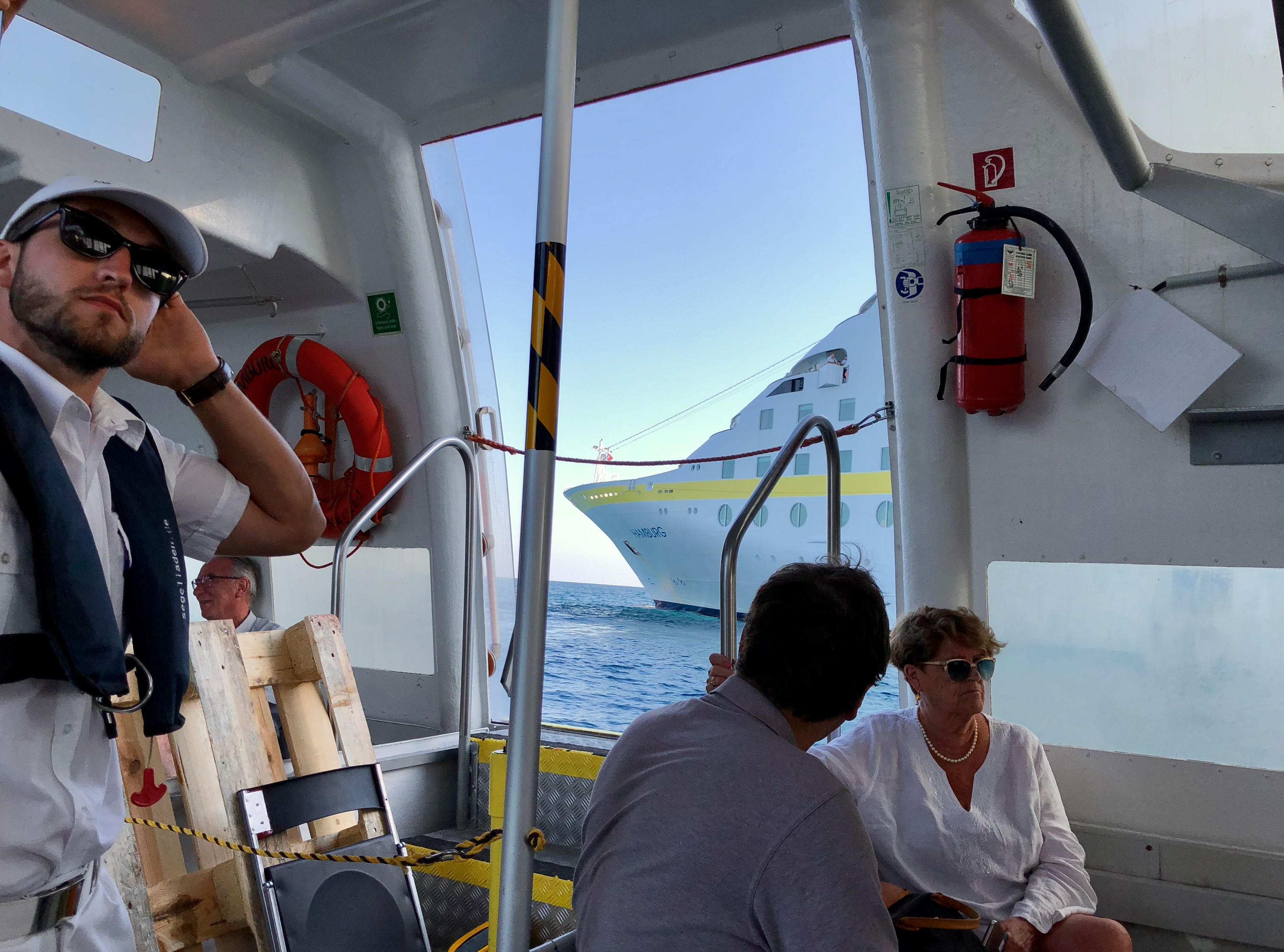 Passagiere steigen per Tenderboot auf ein Kreuzfahrtschiff bei einer Hundekreuzfahrt ein