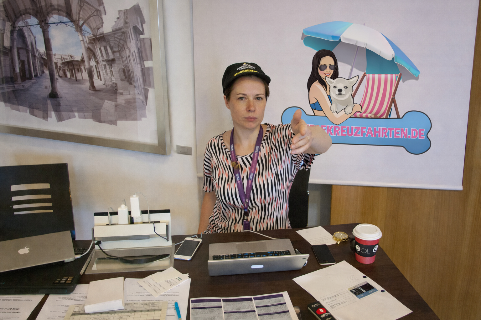 Reiseexpertin des Hundekreuzfahrten Reisbüros sitzt am Tisch der Online Travel Agency OTA