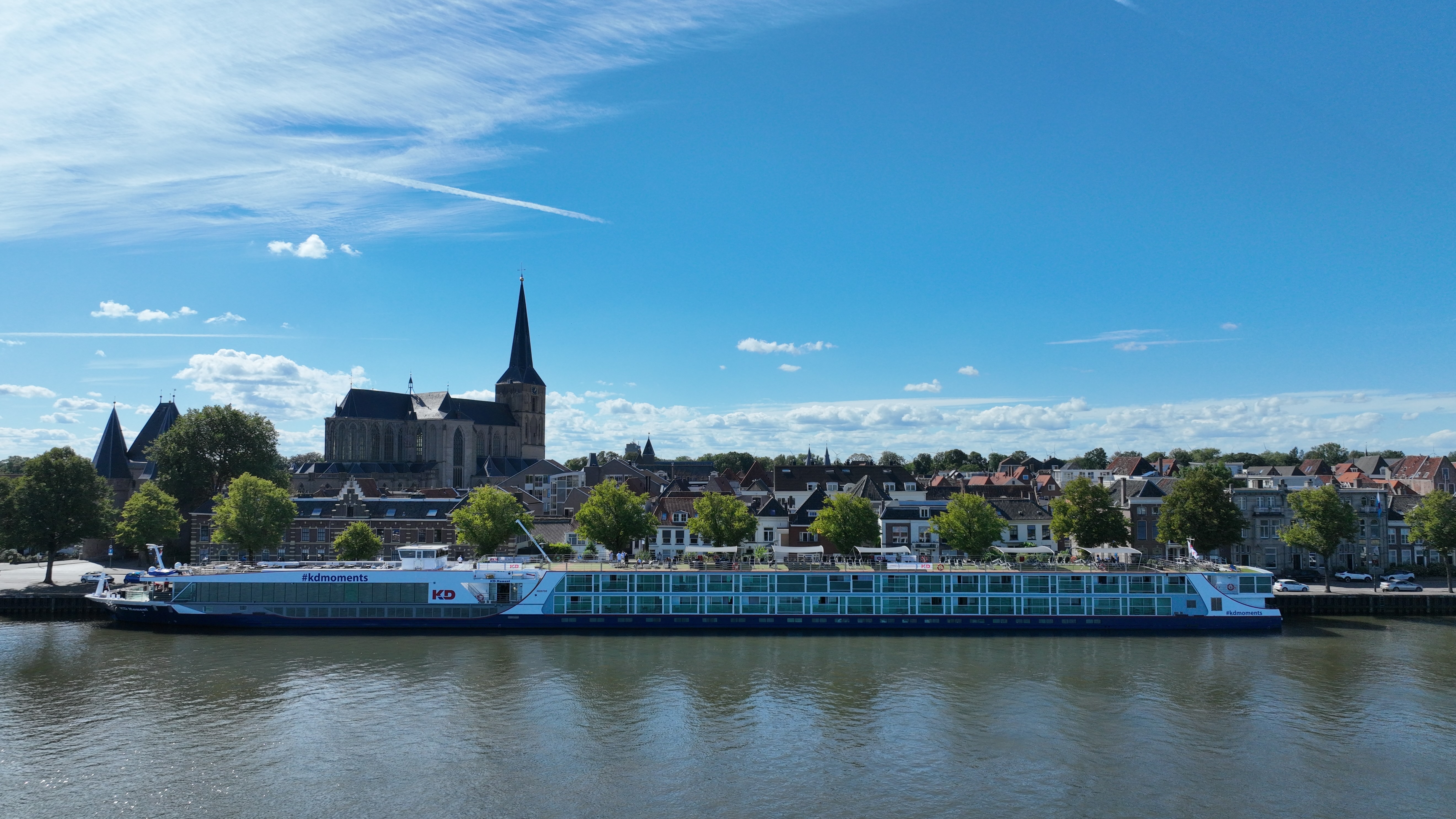 Flusskreuzfahrtschiff KD Moment auf dem Rhein vor einer historischen Stadt während einer Reise mit Hund